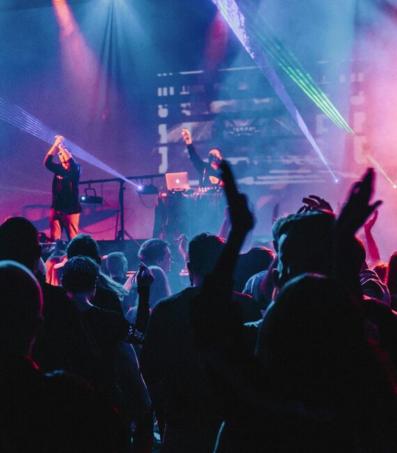 A performer on stage under pink and blue light