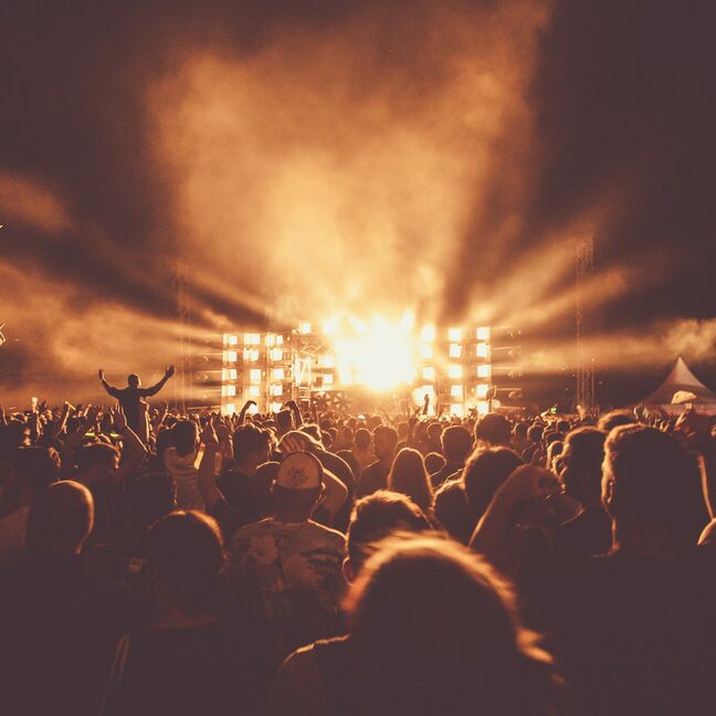 A concert crowd under beams of light